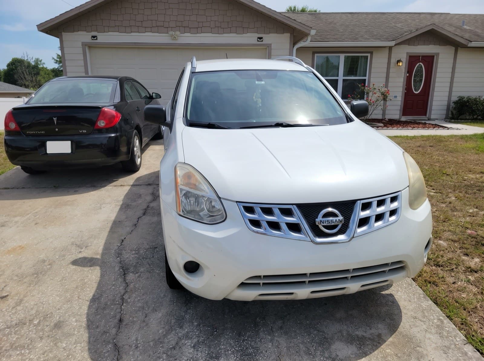 A white compact SUV in a driveway in Deltona, FL, after a Bang AutoGlass mobile glass job